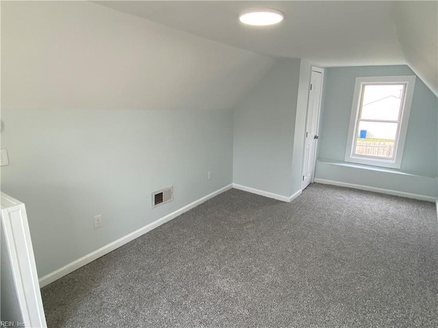 additional living space featuring vaulted ceiling, baseboards, and visible vents