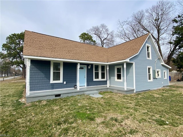 view of front facade with a porch, a front lawn, and roof with shingles