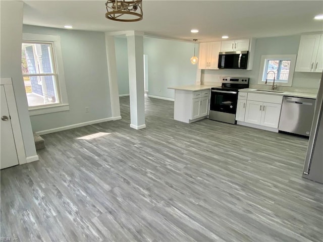 kitchen with a sink, stainless steel appliances, open floor plan, and light countertops