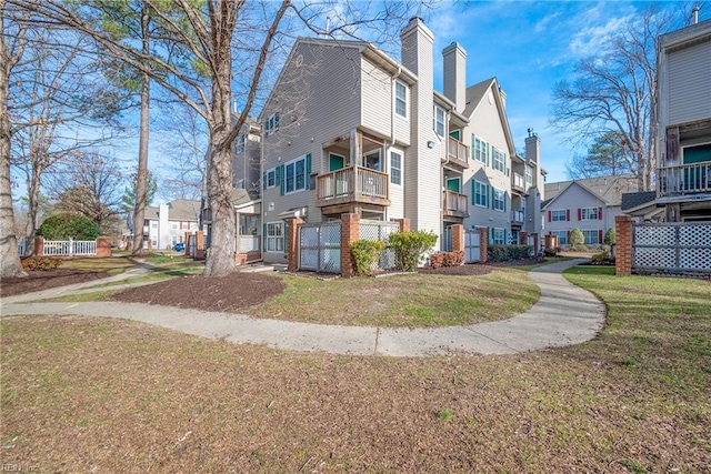 view of property exterior with a residential view, a lawn, and a chimney