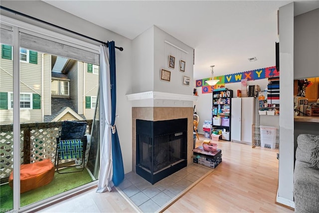 living area with wood finished floors and a tile fireplace