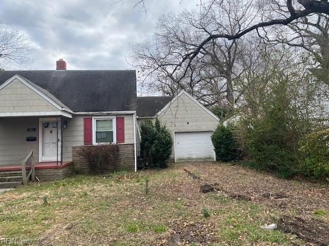 view of front of home featuring driveway, a detached garage, and a chimney