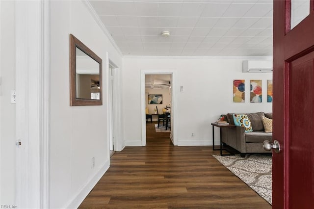 hall featuring dark wood-style flooring, a wall mounted AC, baseboards, and ornamental molding