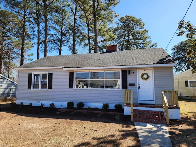 view of front of house featuring crawl space, roof with shingles, and a chimney