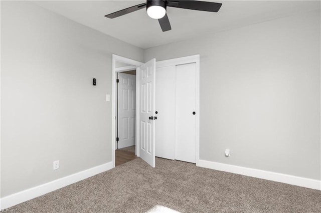 unfurnished bedroom featuring a closet, baseboards, ceiling fan, and carpet flooring