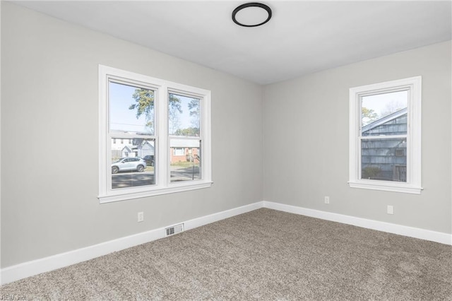 unfurnished room featuring visible vents, baseboards, and carpet floors