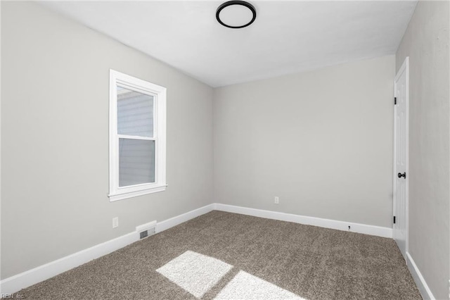 spare room featuring carpet flooring, baseboards, and visible vents