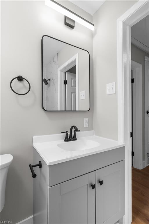 bathroom featuring vanity, toilet, and wood finished floors