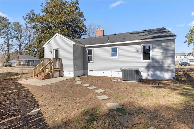 rear view of property with crawl space, central air condition unit, a chimney, and fence