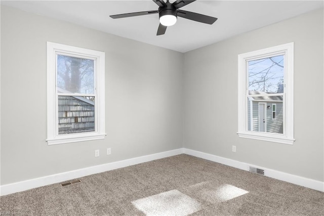 spare room featuring visible vents, baseboards, and carpet flooring