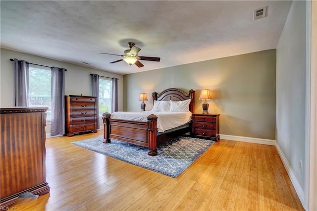 bedroom featuring visible vents, a ceiling fan, light wood-type flooring, and baseboards