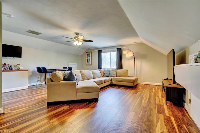 living area featuring visible vents, wood finished floors, baseboards, lofted ceiling, and ceiling fan