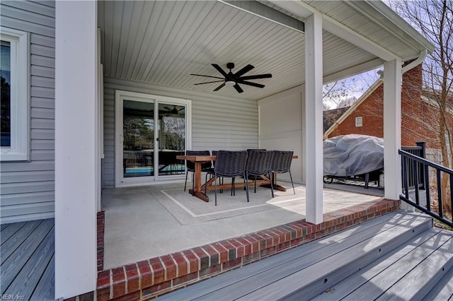 deck with outdoor dining space, a patio, and ceiling fan