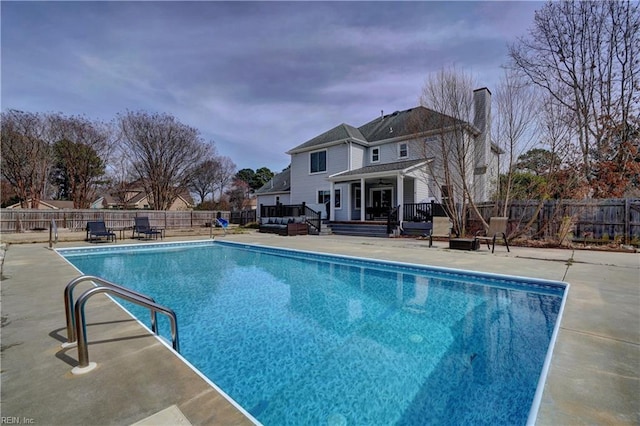 view of pool with a fenced in pool, a wooden deck, a fenced backyard, and a patio area