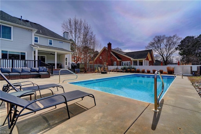 view of swimming pool featuring a patio area, a fenced in pool, an outdoor hangout area, and fence