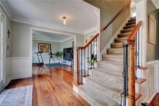 entryway with stairs, baseboards, hardwood / wood-style floors, and crown molding