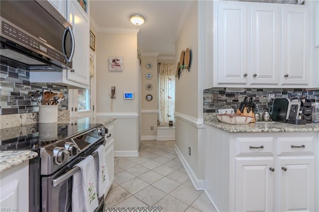 kitchen with light tile patterned floors, electric range oven, crown molding, white cabinetry, and stainless steel microwave