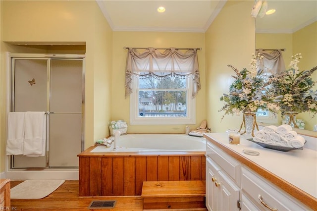 bathroom featuring a bath, visible vents, a stall shower, and ornamental molding