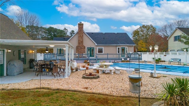 view of swimming pool with a fenced in pool, fence, an outdoor fire pit, a wooden deck, and a patio