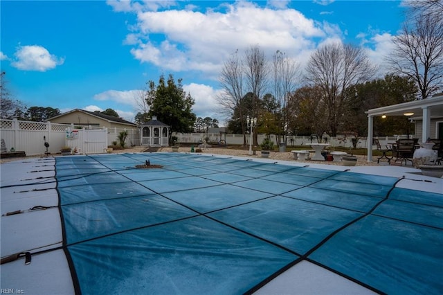 view of swimming pool with a patio, a fenced backyard, a fenced in pool, and an outdoor structure