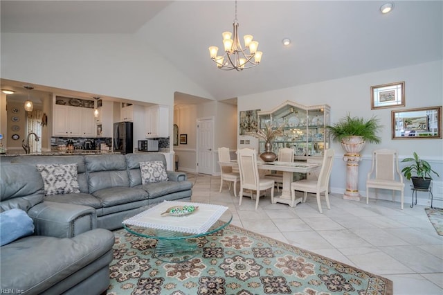 living area featuring light tile patterned floors, baseboards, high vaulted ceiling, and an inviting chandelier