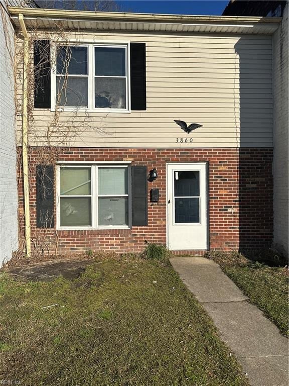 view of front of house featuring a front yard and brick siding