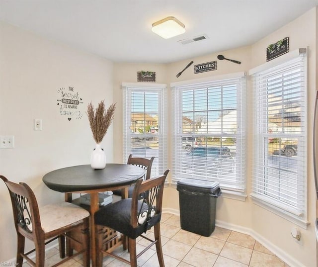 dining area featuring light tile patterned floors, visible vents, and baseboards