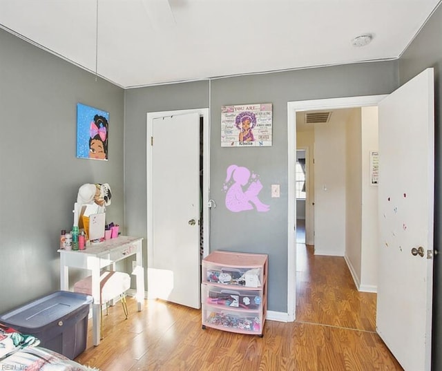 bedroom featuring visible vents, baseboards, and wood finished floors