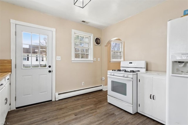 kitchen with visible vents, a baseboard heating unit, light countertops, wood finished floors, and white appliances