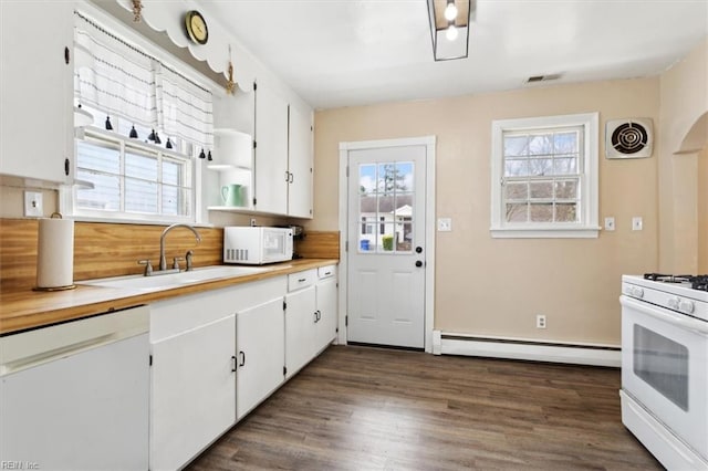 kitchen with a sink, visible vents, white appliances, and baseboard heating