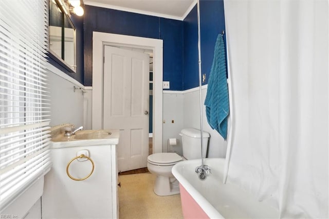 bathroom with a bathing tub, toilet, ornamental molding, and vanity