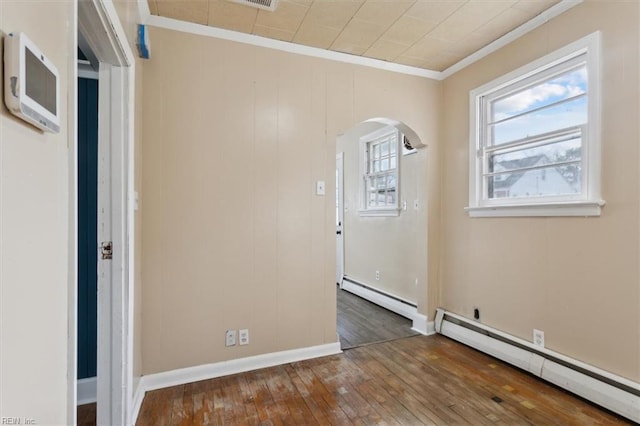 entrance foyer with a baseboard radiator, arched walkways, wood-type flooring, crown molding, and baseboard heating