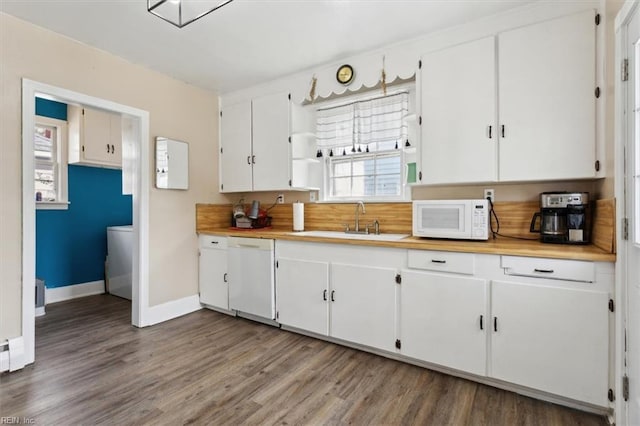 kitchen with light countertops, light wood-style flooring, white appliances, white cabinetry, and a sink