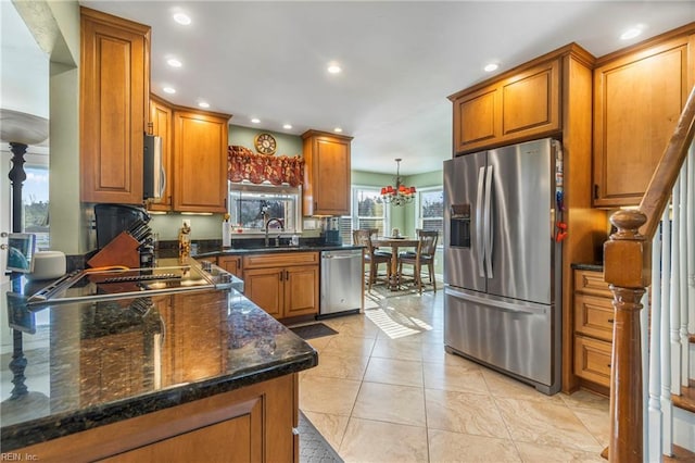 kitchen with brown cabinetry, recessed lighting, appliances with stainless steel finishes, and dark stone countertops