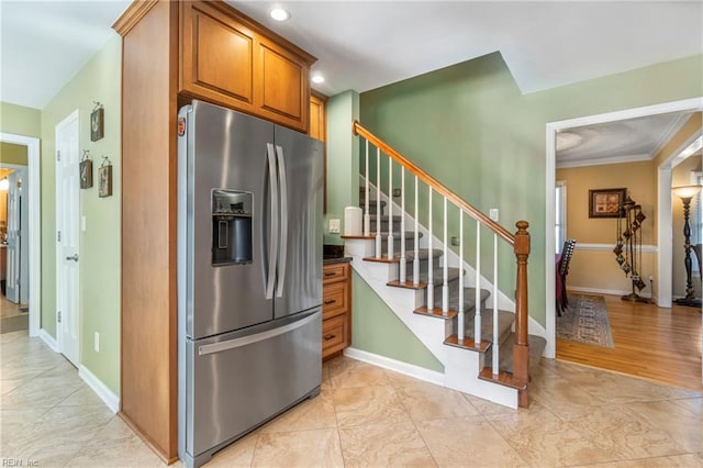 kitchen with recessed lighting, stainless steel fridge with ice dispenser, brown cabinets, and baseboards