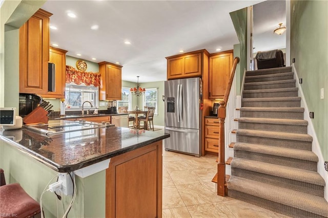 kitchen featuring recessed lighting, stainless steel appliances, brown cabinets, and a peninsula