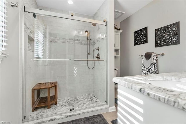 bathroom with visible vents, toilet, a stall shower, and vanity