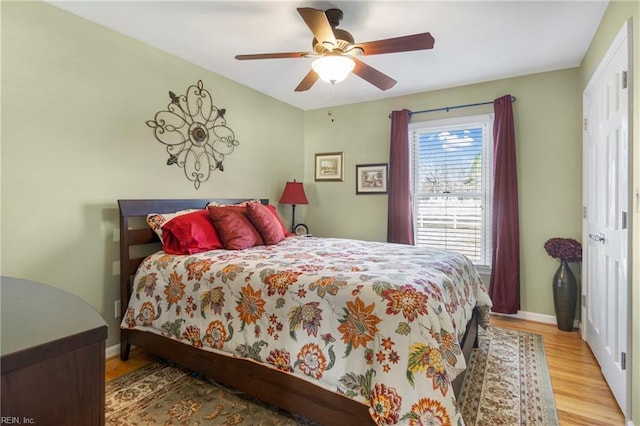 bedroom with wood finished floors, baseboards, and ceiling fan