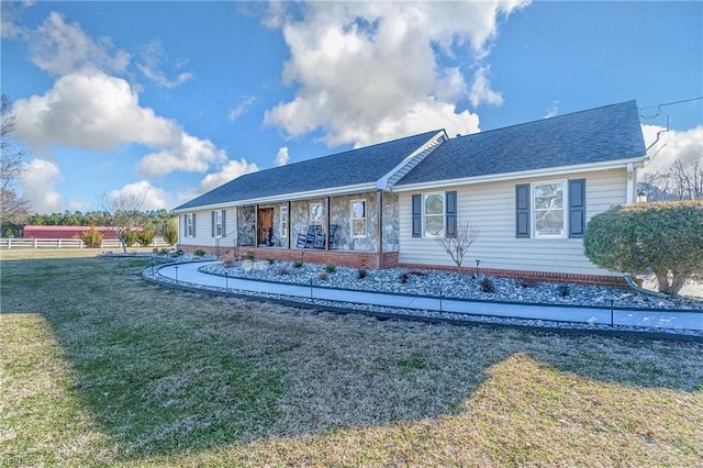 rear view of property featuring a lawn, fence, and roof with shingles