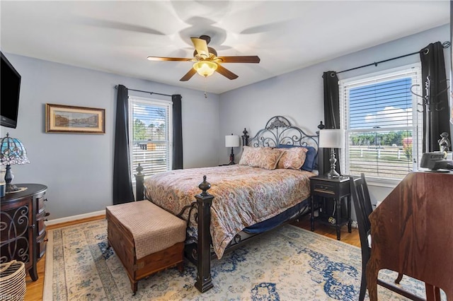 bedroom with ceiling fan, baseboards, and wood finished floors