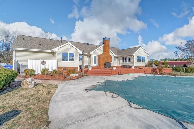 back of property featuring a fenced in pool, fence, crawl space, a chimney, and a patio area