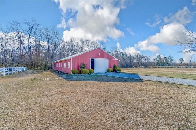 view of pole building featuring a yard and fence