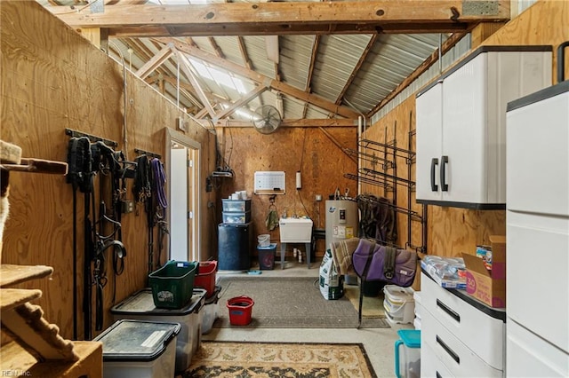 storage room featuring electric water heater and a sink