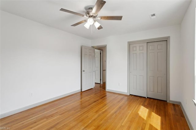 unfurnished bedroom with visible vents, light wood-style flooring, a closet, baseboards, and ceiling fan