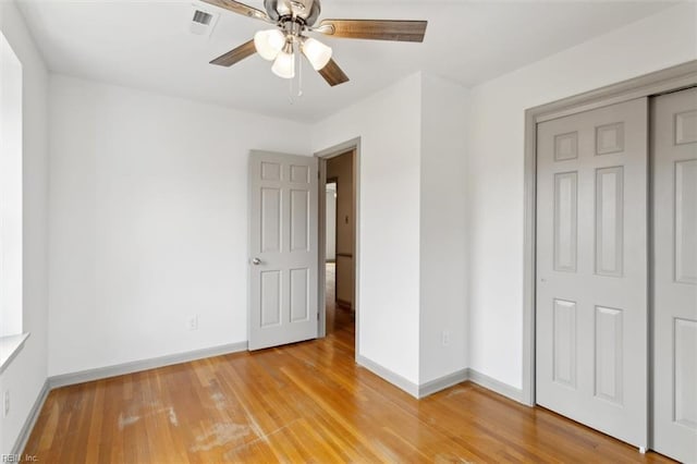 unfurnished bedroom with ceiling fan, a closet, baseboards, and light wood-style flooring