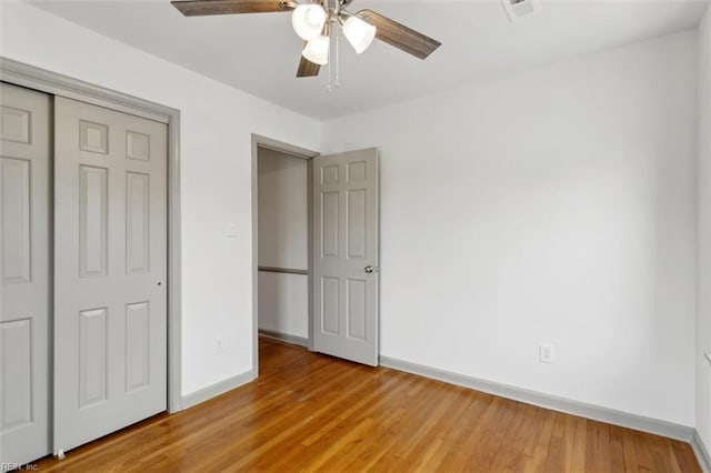 unfurnished bedroom featuring visible vents, ceiling fan, baseboards, light wood-type flooring, and a closet