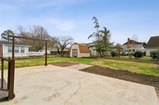 view of yard featuring a storage shed, an outdoor structure, a fenced backyard, and a patio