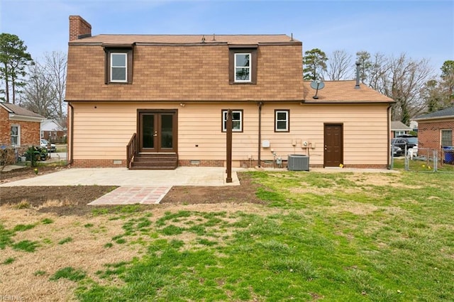 rear view of property featuring fence, a chimney, french doors, a patio area, and a lawn