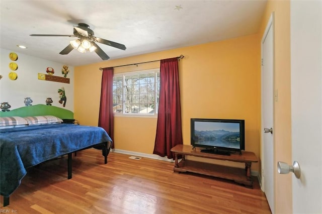 bedroom with baseboards, light wood-style floors, and a ceiling fan