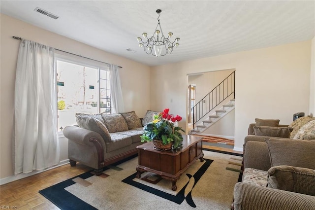 living room featuring visible vents, baseboards, a chandelier, and stairway